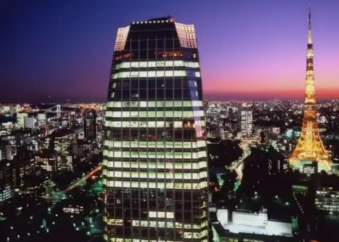 The exterior of XEX ATAGO GREEN HILLS with Tokyo Tower lit up in the background.